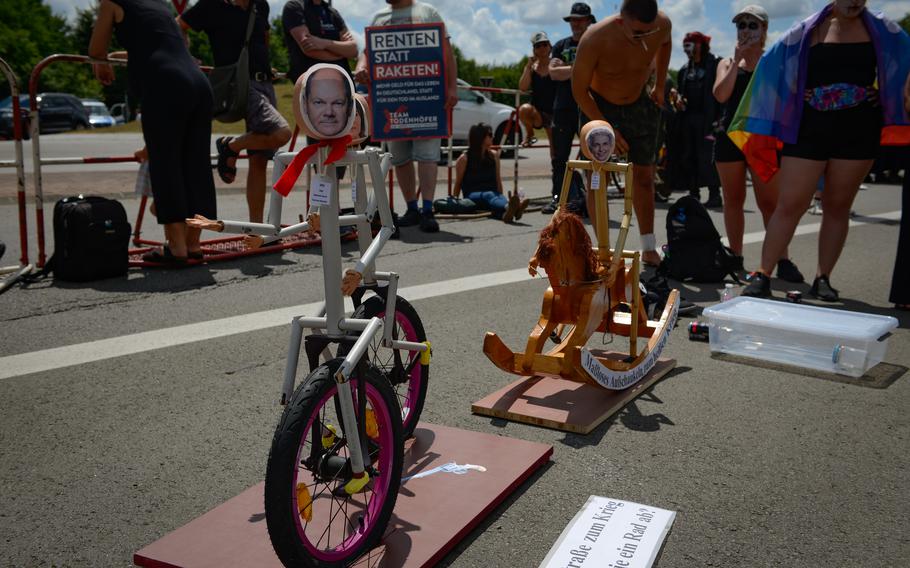 A small art display titled “Marionettes” by activist Peter Meiser is calling out the symbolic “road to war” near the front gate at Ramstein Air Base, Germany, June 25, 2022. The rocking horse symbolizes the increasing escalation of war and conflict, the artist said.