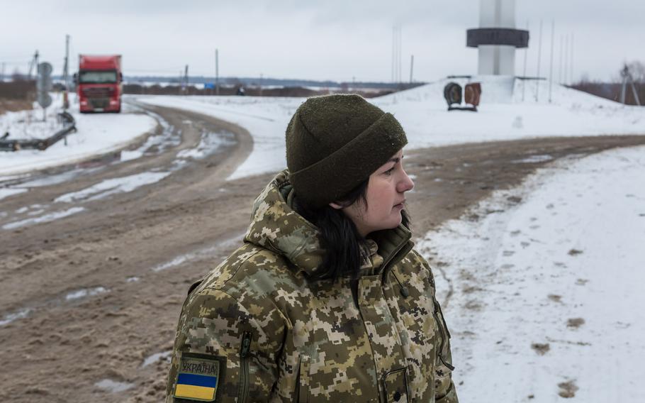 Ukrainian border security officer Oleksandra Stupak, 28, stands near the Three Sisters monument at the junction of the Ukraine, Belarus and Russia borders at the Senkivka crossing on Jan. 28, 2022.