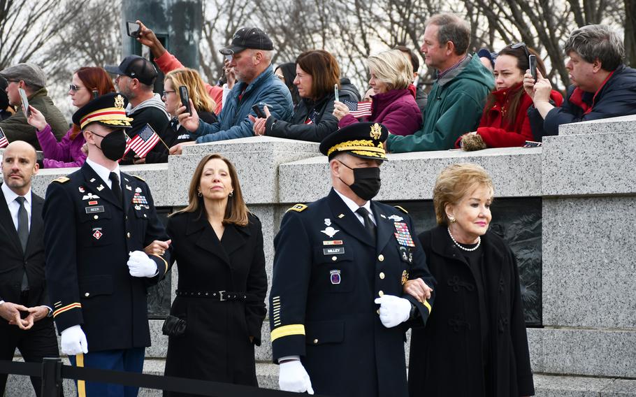 Army Gen. Mark Milley, the chairman of the Joint Chiefs of Staff, escorts former Sen. Elizabeth Dole, the wife of the late Sen. Bob Dole, on Friday, Dec. 10, 2021. Bob Dole died on Sunday, and a public remembrance was held for him at the National World War II Memorial.  