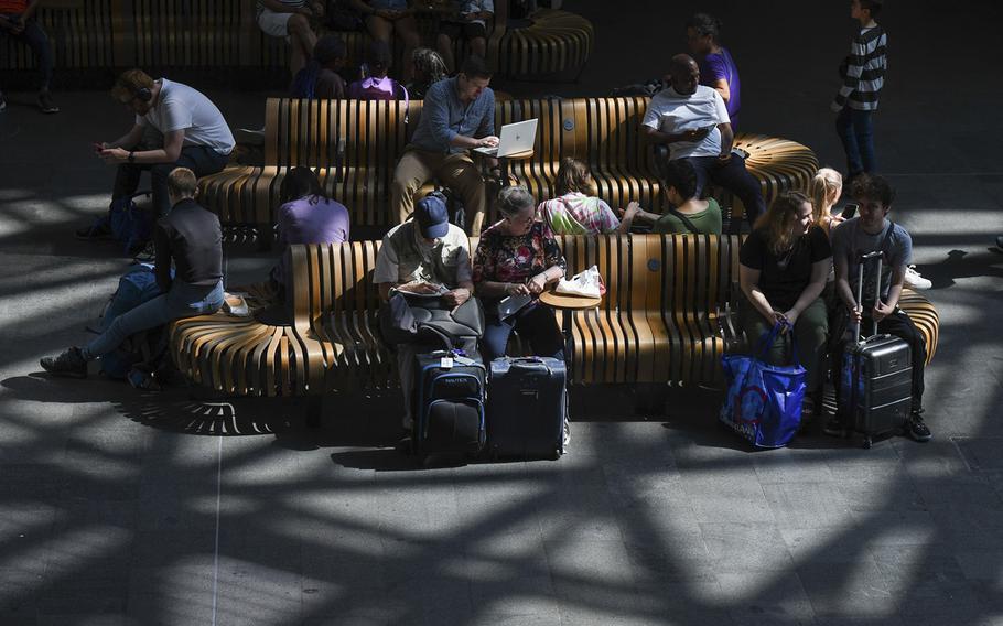Travelers wait for train departures during rail strikes at London King’s Cross railway station in London on Aug. 18, 2022. 