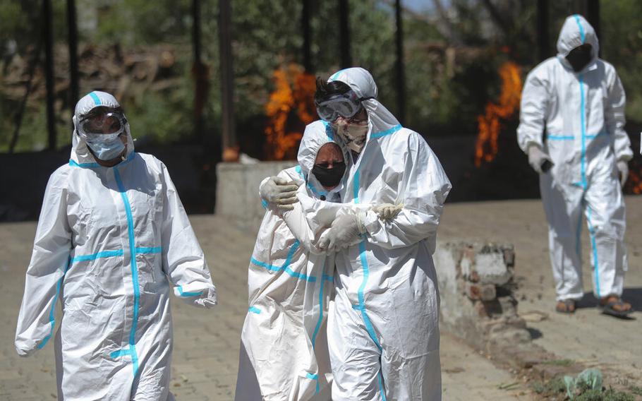 A relative of a person who died of COVID-19 is consoled by another during a cremation in Jammu, India, on April 25, 2021. The World Health Organization said Wednesday, June 22, 2022, that COVID cases in the previous week had jumped by about 45 percent in Southeast Asia.