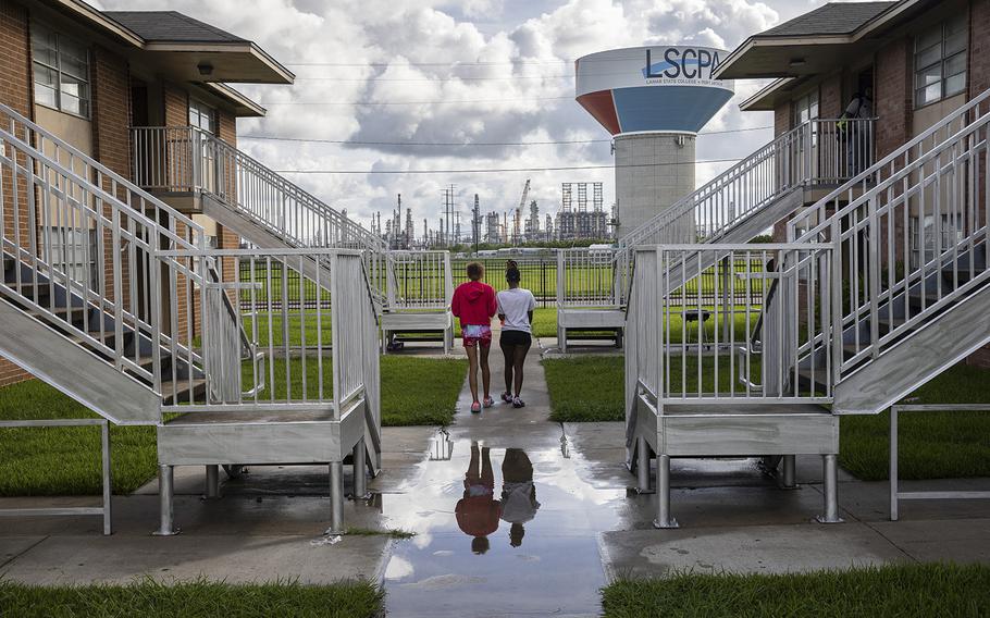 From left, Brandy Smith and Ariel Watson walk through the Prince Hall Village Apartments in Port Arthur, Texas. 