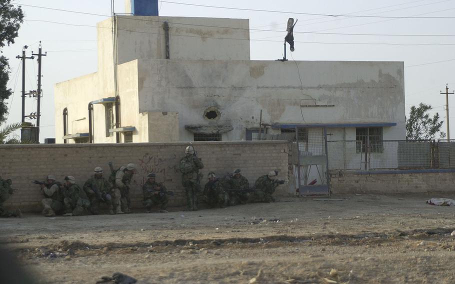 Marines prepare to storm a building under the shot hole from an anti-tank rocket during a raid that netted weapons, intelligence and the capture of several Baath Party officials. 