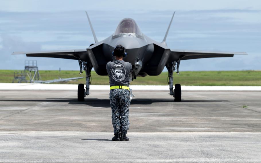 A Japanese airman marshals an F-35A Lightning II during a hot-pit refuel at Andersen Air Force Base, Guam, Aug. 28, 2023.