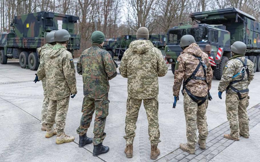A German military instructor, third from left, introduces Ukrainian soldiers to the Patriot air defense system during a training event in Germany in an undated photo shared Feb. 17, 2023, by the Ukrainian Defense Ministry on Twitter. Fast weapons deliveries will be critical to Ukraine's war effort, Ukrainian officials and NATO analysts say. 
