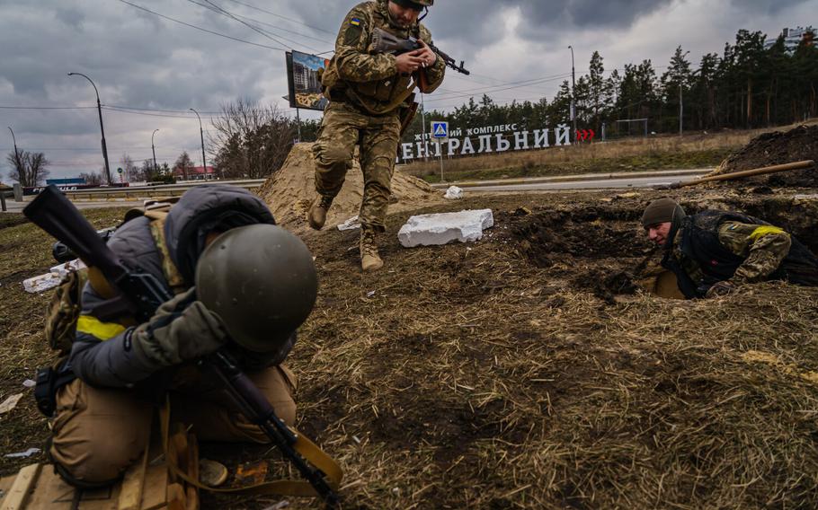 Ukrainian soldiers rush to brace themselves against incoming artillery fire from Russian forces while defending the town of Irpin and the civilians fleeing it, in Irpin, Ukraine, Sunday, March 6, 2022.