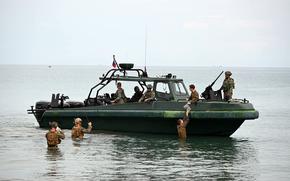 U.S. Marines wade to meet their comrades and Filipino counterparts in a small boat off the western coast of Palawan, Philippines, during a Balikatan drill on April 28, 2025. 