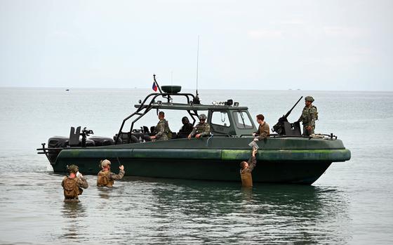 U.S. Marines wade to meet their comrades and Filipino counterparts in a small boat off the western coast of Palawan, Philippines, during a Balikatan drill on April 28, 2025. 
