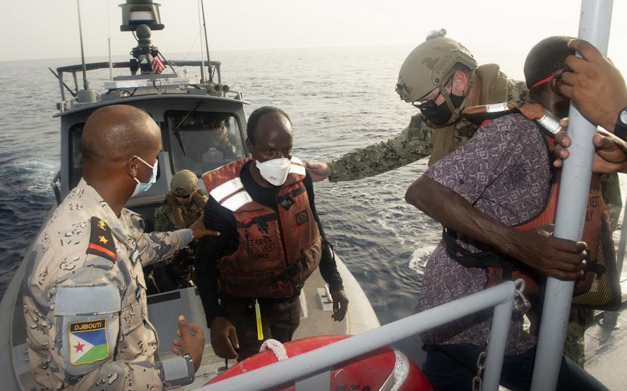 U.S. Coast Guard Cmdr. Benjamin Lehrfeld, right, Task Force 68.6 commander, and members of the Djibouti Coast Guard help four Somali fishermen switch boats, June 17, 2021. The fishermen were stranded at sea after a mechanical failure and were without food or water for several days before they were rescued in the Gulf of Aden, June 16, 2021. 