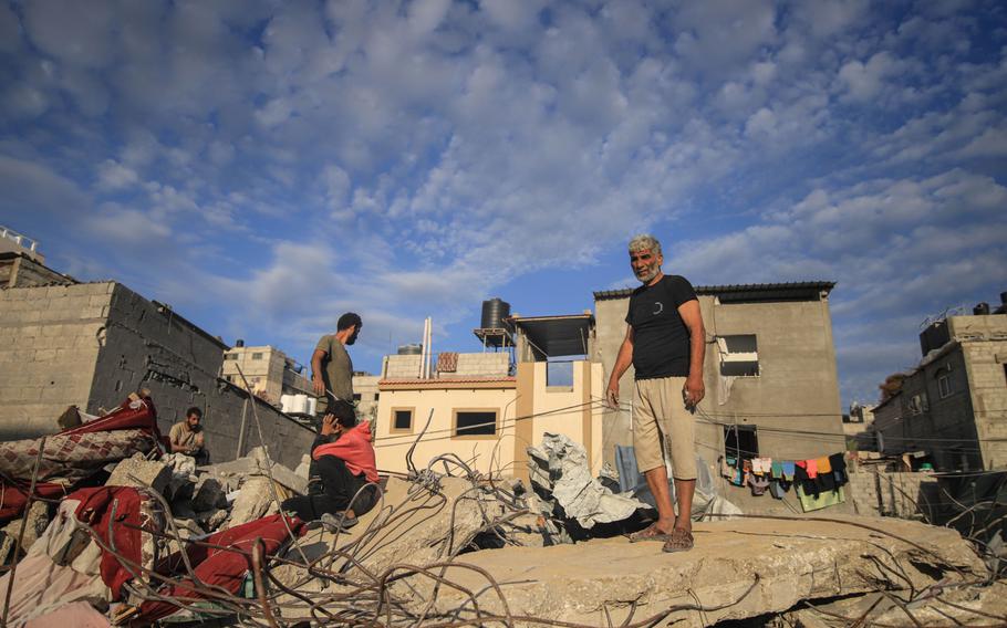 Palestinians in the rubble of destroyed buildings hit by Israeli missiles in the center of Khan Younis, southern Gaza, on Monday, Oct. 30, 2023.