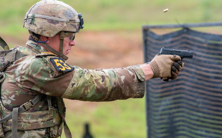 A soldier fires a pistol at a target