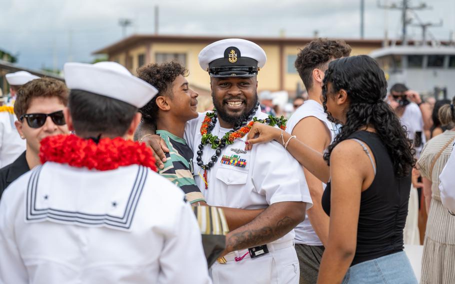 A sailor smiles with loved ones.