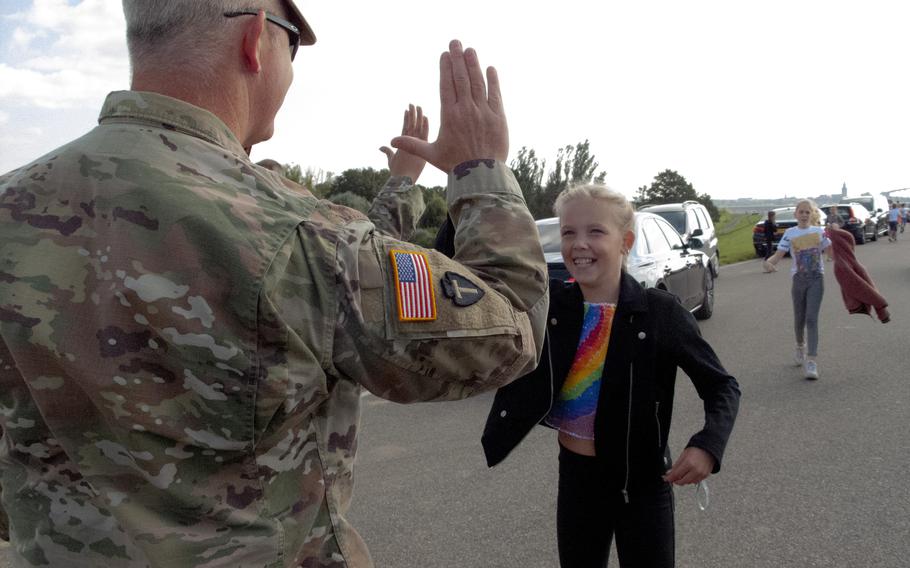 Maj. Mark Fitzgerald of the Texas National Guard high-fives a Dutch girl as she and her classmates from De Oversteek school arrive on Sept. 20, 2021, for a ceremony to mark the 77th anniversary of the crossing the Waal River in Nijmegen, Netherlands, during Operation Market Garden in World War II.