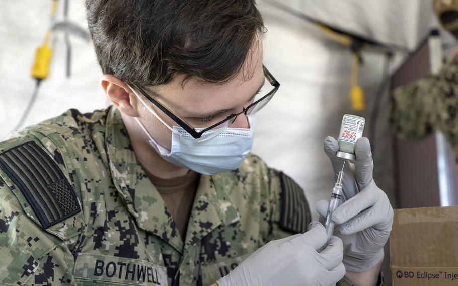 A Navy hospitalman fills a syringe with the Moderna COVID-19 vaccine earlier this year at Naval Hospital Okinawa. 