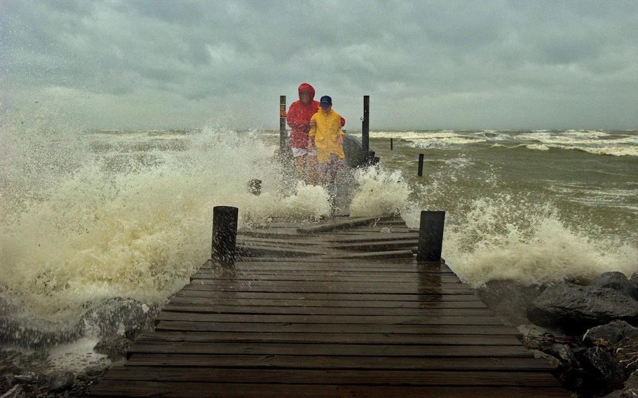 Elise Feldman stands by her son Josh Feldman, 11 of Leonardtown, Md., cautiously watching their footing as the pier breaks up from the force of the waves pounding the boards loose as Hurricane Isabel slams into the eastern seaboard and into the mid-Atlantic states September 18, 2003.