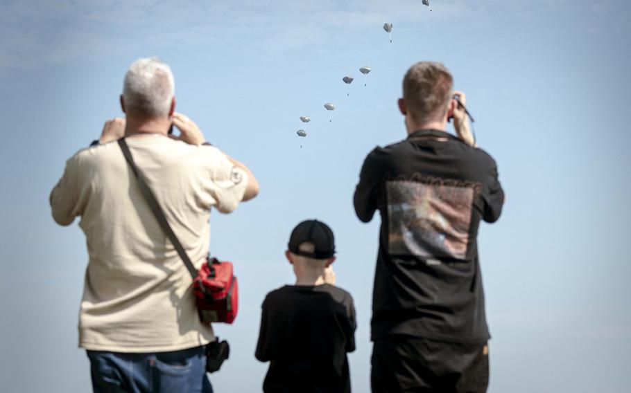 Spectators watch soldiers of the 173rd Airborne Brigade parachute outside of the Joint Multinational Readiness Center Hohenfels Training Area, Germany, for Exercise Saber Junction on Sept. 4, 2024. 