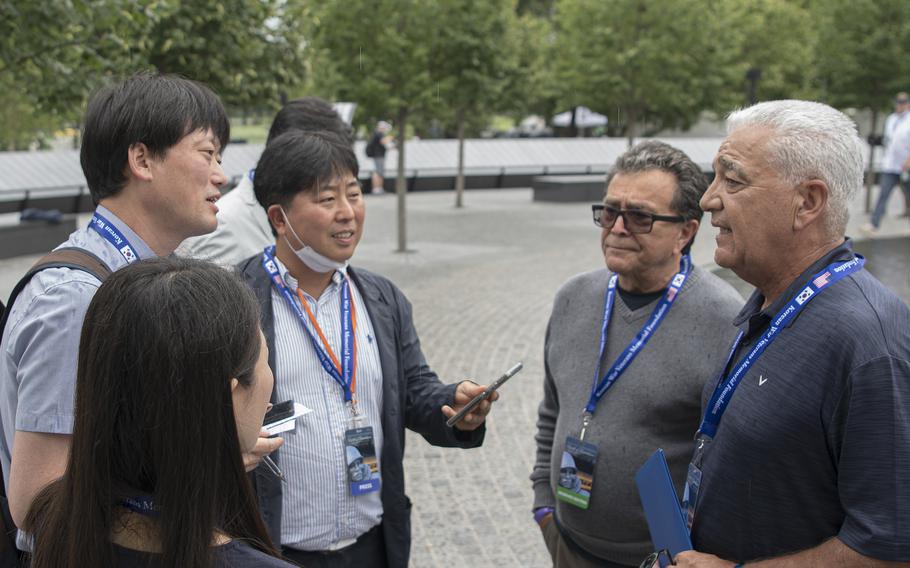 Reporters from the daily South Korean newspaper Munhwa interview Jeff Cribben, as his uncle, Navy veteran Robert Camudio looks on at the unveiling ceremony of the new Wall of Remembrance at the Korean War Memorial in Washington, D.C., on Tuesday, July 26, 2022.