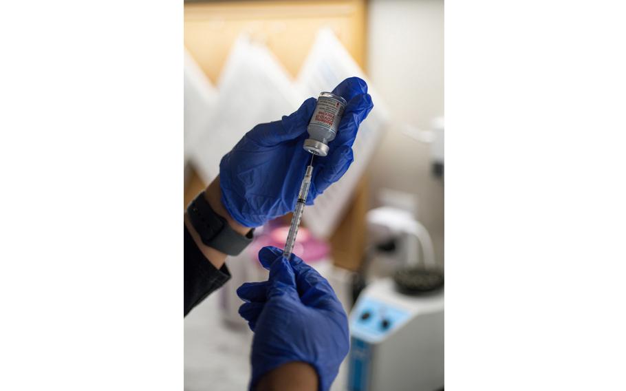 A health care worker prepares a dose of the Moderna COVID-19 vaccine at the CareNow Denver University urgent care center in Denver on Nov. 16, 2021.