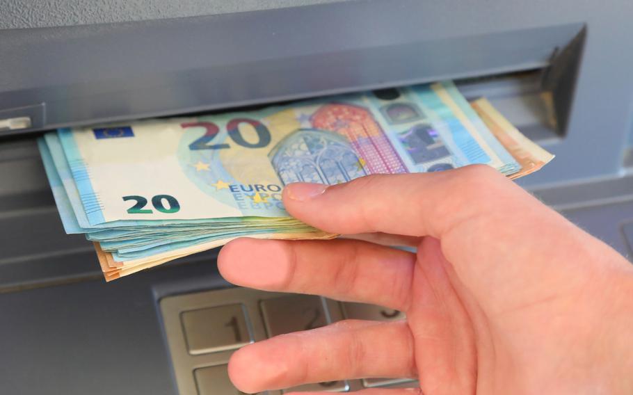 Hand withdrawing euro banknotes from an ATM machine in Central Europe