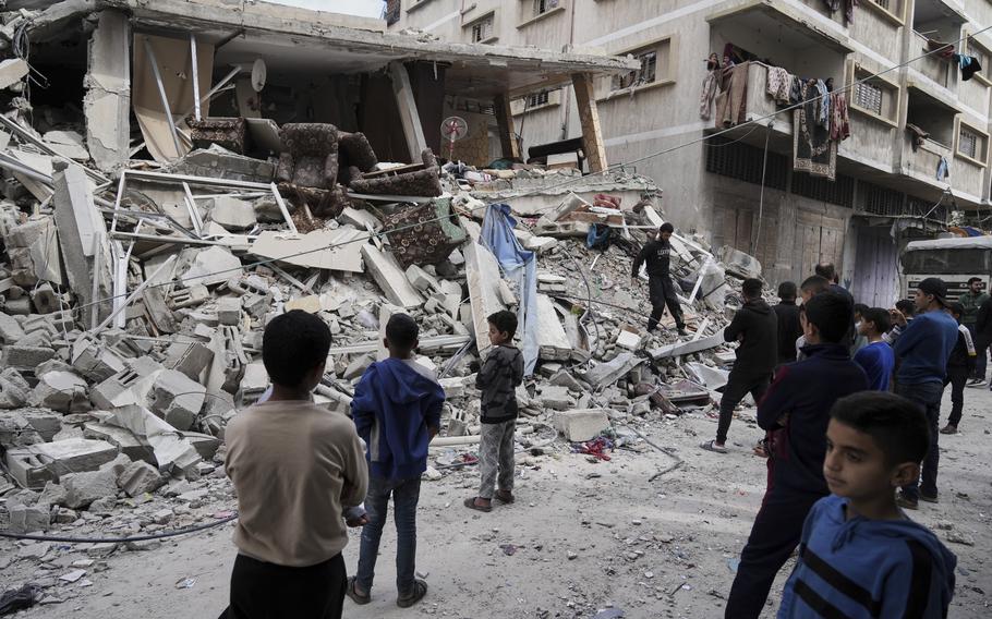 Palestinians inspect the damage after an Israeli army airstrike