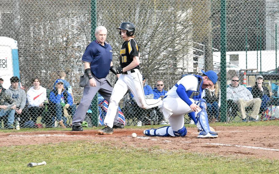 Der Stuttgarter Liam Bernhard überquert die Platte, als der Ball während des ersten Spiels eines Doppelsamstags auf dem Basbeall-Feld in der Nähe des Southside Fitness Centers auf der Ramstein Air Force Base in Deutschland unter den Ramstein Wide Receiver Chuck Wheeler gleitet.