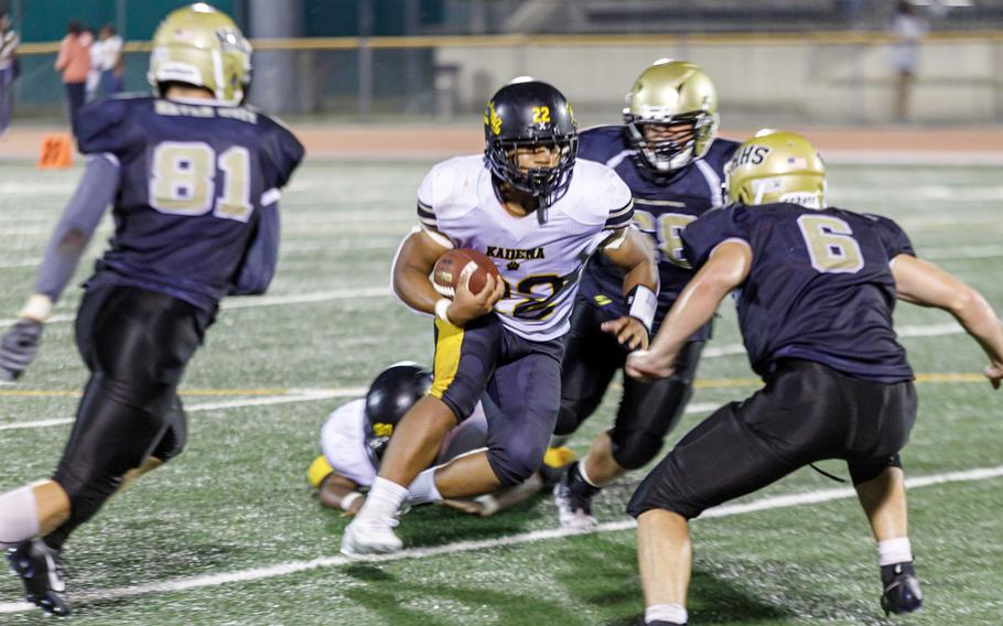 Kadena running back Jeremiah Drummer looks for room against Humphreys' Luke Robinson and William Dales.