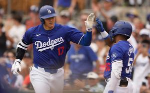 Los Angeles Dodgers designated hitter Shohei Ohtani greets Dylan Campbell, right, after hitting a two-run home run against the San Francisco Giants during the sixth inning of a spring training baseball game Tuesday, March 12, 2024, in Phoenix.