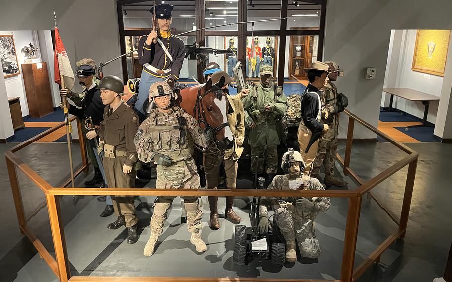 Military uniforms are on display in a museum.