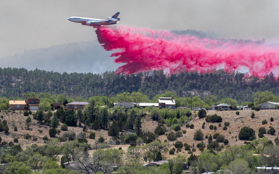A slurry bomber dumps the fire retardant between the Calf Canyon/Hermit Peak Fire and homes on the westside of Las Vegas, N.M., Tuesday, May 3, 2022. Several types of aircraft joined the fight to keep the fire away for the Northern New Mexico town. 
