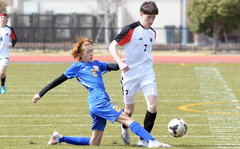 Yokota's Tommy Vogeley slide-tackles the ball away from Nile C. Kinnick's Kuo Nishiyama during the championship match in the Perry Cup soccer tournament. Nishiyama had both goals as the Red Devils shut out the Panthers 2-0.