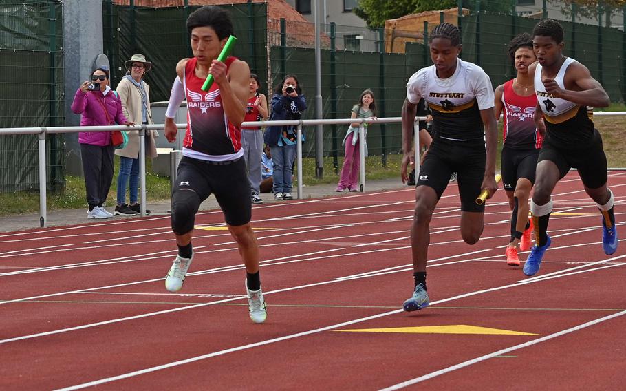 Kaiserslautern’s Joshua Kim speeds away after taking the baton from teammate Denver Dait in the boys 4x100-meter relay at the 2025 DODEA-Europe track and field finals, in Kaiserslautern, Germany, With teammates Quincy Seaberry and Noah Perez, the Raiders won the race in 44.29 seconds.