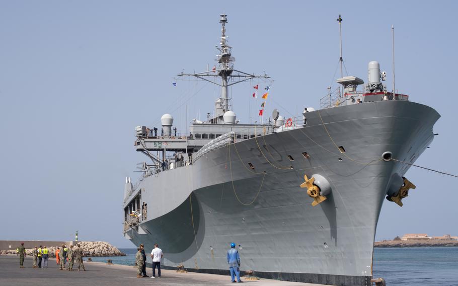 A Blue Ridge-class command and control ship sits at a dock. 
