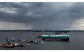 The vehicle carrier Tosca passes through an open section of the Federal channel as crane barges continue work on clearing the debris from the Francis Scott Key Bridge on May 29, 2024, more than two months after the catastrophic collapse.