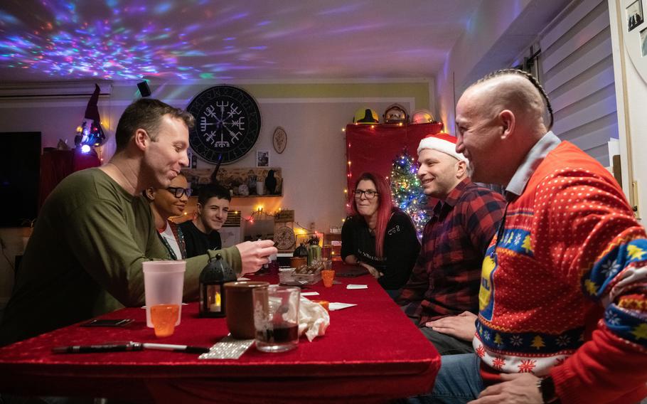 Army Staff Sgt. Matthew Fox, from left, Staff Sgt. Mary Porter, T.J. Buerger, Manuela Buerger, Sgt. John Oliviero and Ulf Buerger play Cards Against Humanity on Christmas Eve 2023 at the Buergers’ home in Zweibruecken, Germany.