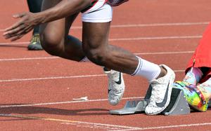 A sprinter uses the blocks for a quick start.