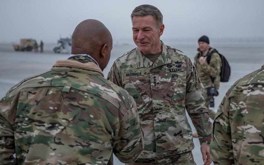 Army Command Sgt. Maj. Jermain Baldwin, left, with the Combat Aviation Brigade, 1st Armored Division greets Gen. James C. McConville, the Army’s chief of staff, at the 33rd Air Base in Powidz, Poland, on Dec. 18, 2022. 