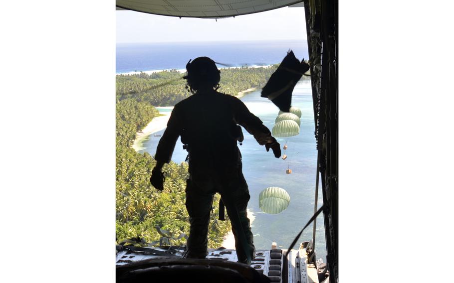 Staff Sgt. William Jenkins, a loadmaster with the 36th Expeditionary Airlift Squadron at Yokota Air Base, Japan, watches an Operation Christmas Drop bundles fall to Falalop, an island in the Federated States of Micronesia, Tuesday, Dec. 5, 2023.