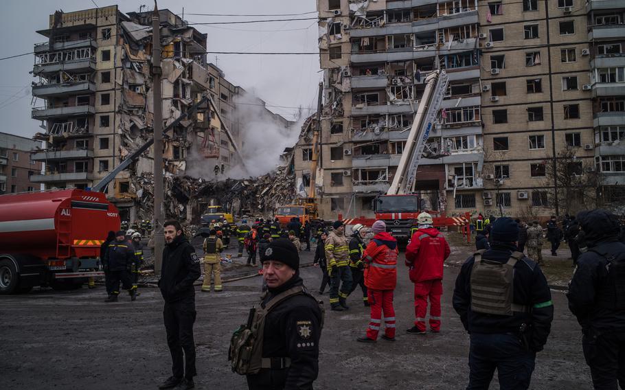 Rescuers surround the remains of an apartment complex on Jan. 15, 2023 in Dnipro, Ukraine that was hit by a Russian missile the day before.
