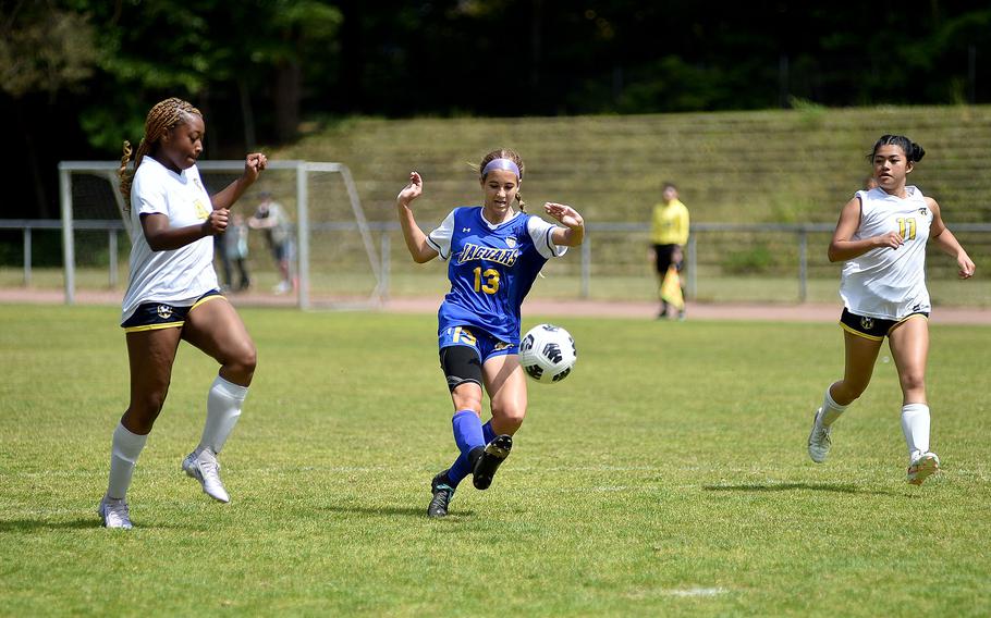 Sigonella striker Madison Hoy shoots between Ansbach defenders Mya Henderson and Marga Marzan during the second day of round-robin action at the 2025 Division III DODEA European championships on May 20, 2025, at Rothenborn Stadion in Landstuhl, Germany.