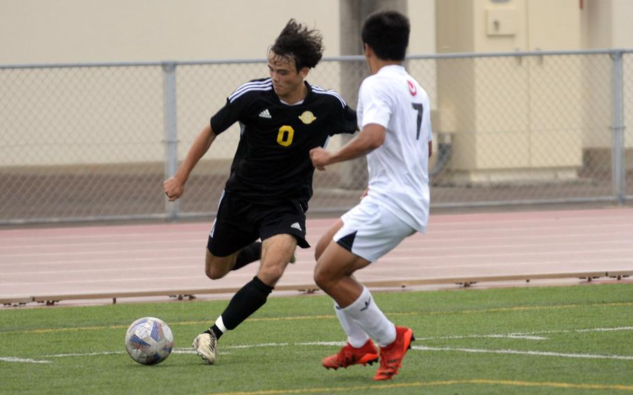 Kadena’s Allen Madlener gets set to boot the ball past Okinawa Christian’s Jarin Ferido during Wednesday’s Okinawa boys soccer match. The Panthers won 10-1.