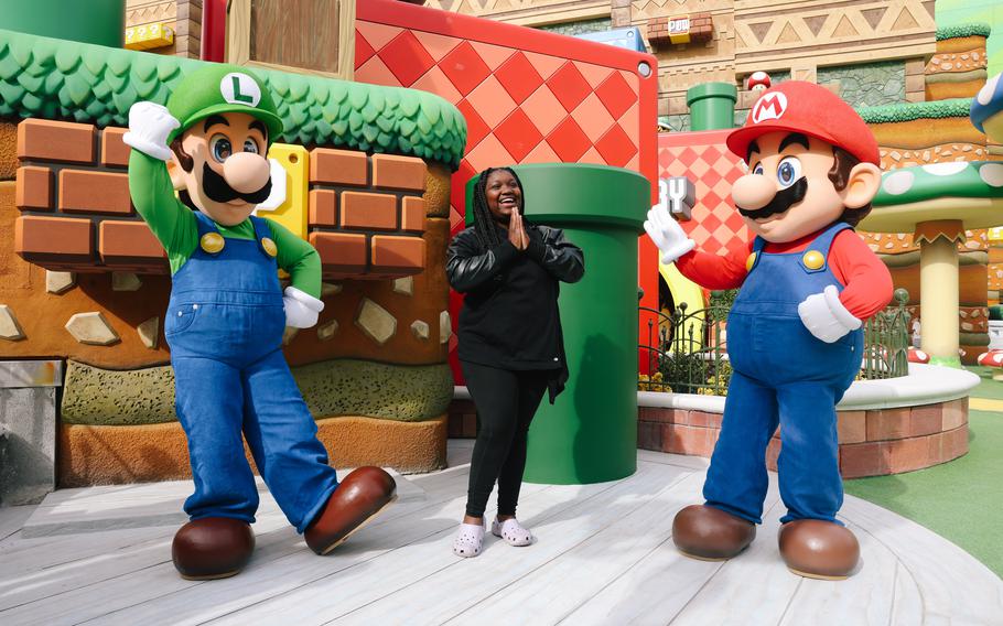 LJ Hale poses with Luigi and Mario during technical rehearsals Jan. 12 for Super Nintendo World. The Universal Studios Hollywood theme park opens to the public on Feb. 17. 