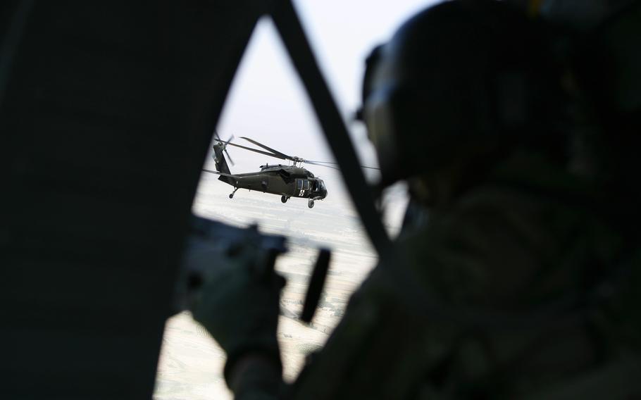 Staff Sgt. Ryan Musterman of Company A, 7th Battalion, 101st Aviation Regiment, mans a M240H machine gun while covering a medevac helicopter from the “chase” Blackhawk on June 19, 2011, in Kandahar province, Afghanistan. 