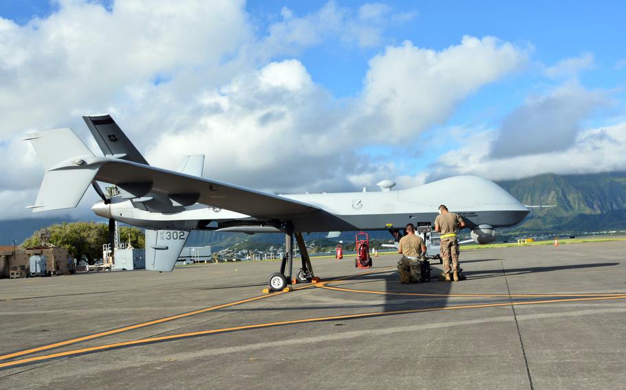 Technicians prepare an Air Force MQ-9 Reaper drone just before takeoff at Marine Corps Base Hawaii, Sept. 27, 2021.