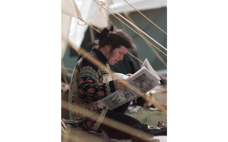 A lady starts her morning by reading a paper in the Brazda refugee camp in Skopje, Macedonia.