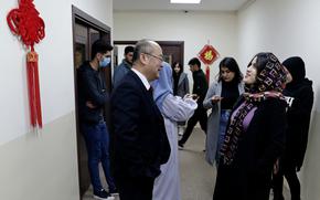 A Chinese teacher, center left, speaks with a student outside a classroom in the Chinese language department at Salahaddin University in Irbil, Iraq, Wednesday, Jan. 19, 2021. The Chinese language school in northern Iraq is attracting students who hope to land jobs with a growing number of Chinese companies in the oil, infrastructure, construction, and telecommunications sectors in the region. (AP Photo/Khalid Mohammed)