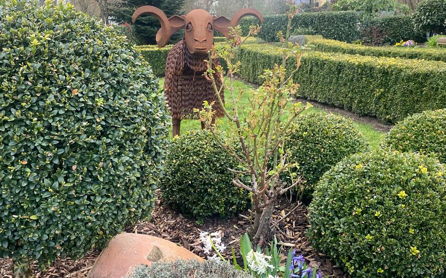 The exterior of the Oelmuehle hotel and restaurant features a garden with this metal animal sculpture standing amid walking paths, flowers and manicured greenery.