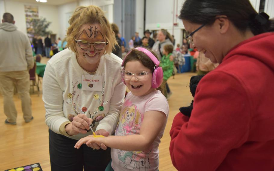 A family enrolled in the Exceptional Family Member Program enjoys holiday activities at Fort George G. Meade, Md., during a party on Dec. 12, 2023.