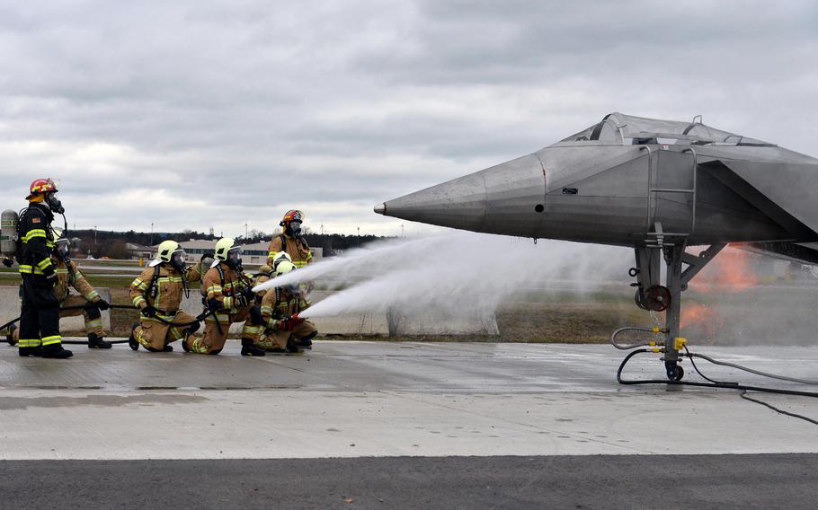Firefighters put out an engine fire by spraying water on an aircraft