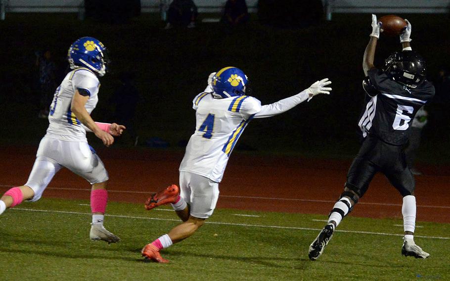 Zama's Jeremiah Georges hauls in a touchdown pass ahead of Yokota defenders Dylan Tomas and Royce Canta.