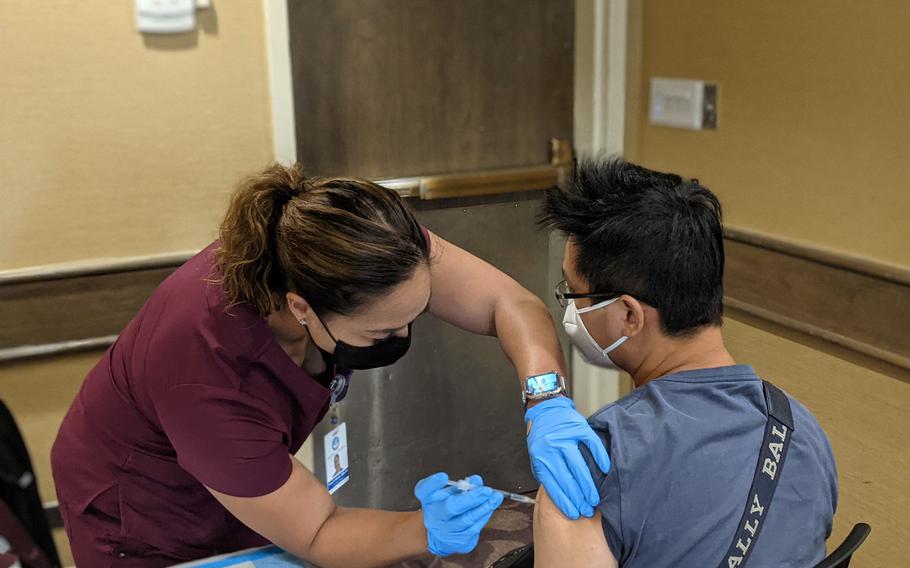 Frances Nicdao, a clinical nurse manager of the American Medical Center in Guam, administers a Pfizer vaccine dose to a Taiwanese tourist at the Hyatt Regency, a designated "vacation and vaccination" hotel. 